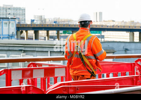 Rückansicht der Bauarbeiter zu Fuß in einer Baustelle in Canary Wharf, London Stockfoto