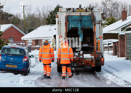 Arbeitnehmer mit Abfall Recycling Sammlung Lkw entlang der Straße im Schnee in Newtownabbey Nordirland fahren Stockfoto