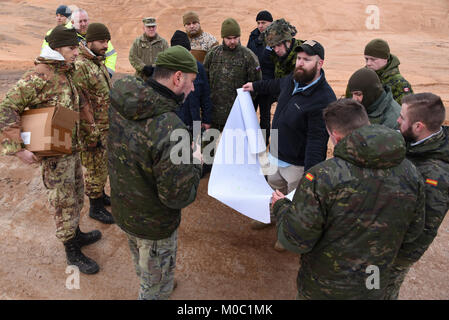 Bobby Hoffmann (5. von rechts), eine Auswahl und Ausbildung Land Programm Spezialist mit der US Army Training Support Aktivität Europa (TSAE) und Soldaten aus Spanien, Slowakei, Kanada, Lettland, Italien und Polen diskutieren ein Tank Bereich trocken Übung in Adazi Training Area, Lettland, Jan. 09, 2018. TSAE führte eine Endkontrolle einer neu gebauten Tank als TSAE ist Unterstützung von NATO-Verbündeten in Osteuropa entwickeln ihre Auswahl und Ausbildung Infrastrukturen. (U.S. Armee Stockfoto