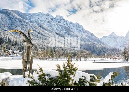 Sonnigen Tag am See Jasna in Kranjska Gora durch die Statue eines Gold gehörnten Steinbock bewacht Stockfoto