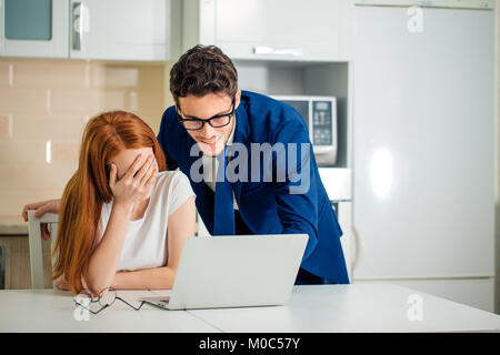 Paar genießt die Zeit zusammen surfen Laptop. Mann mit Anzug Frau in T-Shirt Stockfoto