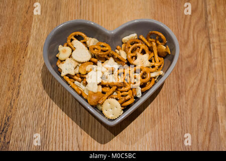Keks Brot in Keramik Herz Schüssel auf hölzernen Tisch Stockfoto