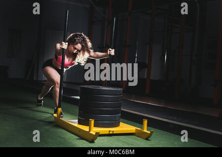 Schlitten schieben Frau schob Gewichte Training Übung Stockfoto