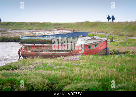 Orford Suffolk Coast, Blick entlang des Ufers des Flusses Alde bei Orford mit einem Paar, das den Suffolk Coast Path in der Ferne, Suffolk, Großbritannien, zu Fuß führt Stockfoto