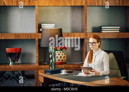 Geschäftsfrau Brille mit digitalen Tablette im Büro Stockfoto