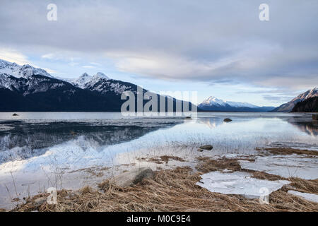 Dunkle Wolken über den Chilkat Mündung in der Nähe von Haines, Alaska mit einer Flut bei Sonnenuntergang im Winter. Stockfoto