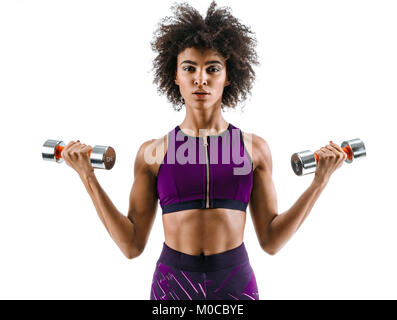 Sportliche Mädchen Übungen mit Hanteln am Bizeps. Foto von starken afrikanischen Mädchen auf weißem Hintergrund. Kraft und Motivation. Stockfoto