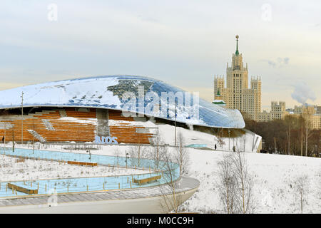 Zaryadye Nature-Landscape Park im Winter. Glas Vordach gegen den Hintergrund der alten Wolkenkratzer Stockfoto