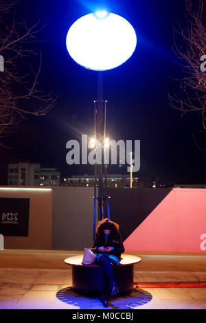 Eine Frau sitzt unter einem Lampounette durch Kippen, Teil der Lumiere London licht Festival 2018, auf der King's Boulevard, riesige Größe Lampen, die eine surre Stockfoto