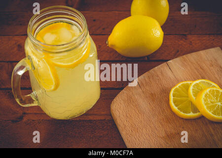 Frische Limonade mit Zitronen und Zitronenscheiben auf hölzernen Hintergrund Stockfoto
