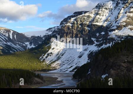 Als die Sonne beginnt, nach unten zu gehen, es wirft einen Schatten über das Tal und den Fluss unten, mit großen Schnee Berge in der Ferne abgedeckt Stockfoto