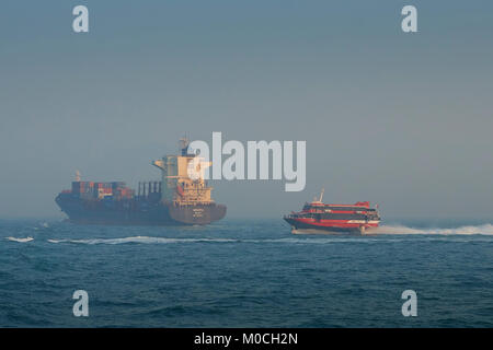 Containerschiff, BINDIIPSA, verlassen den Osten Lamma Kanal, Hong Kong. Ein TurboJet Boeing Jetfoli Fähre auf dem Weg nach Macau, Hinter. Stockfoto