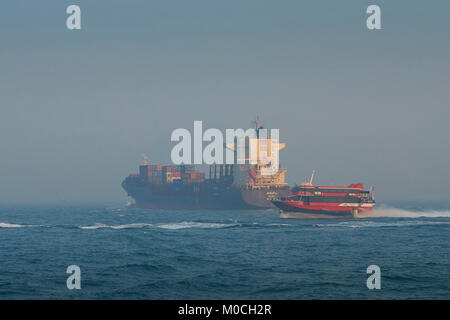Containerschiff, BINDIIPSA, verlässt East Lamma Channel, Hong Kong. Eine Boeing Jetfoli-Passagierfähre mit Turbojet fährt nach Macau, hinter China vorbei Stockfoto