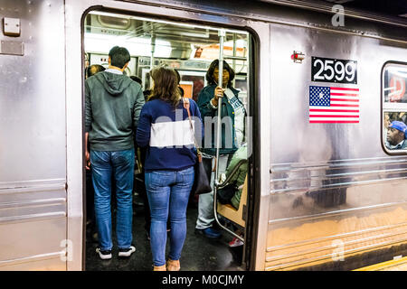 New York City, USA - Oktober 28, 2017: Die Menschen in der U-Plattform Transit in NYC U-Bahn Station auf der Fahrt mit dem Zug, Menschen zusammengepfercht Masse mit o Stockfoto