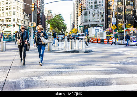 New York City, USA - Oktober 28, 2017: Zwei Frauen sprechen über Columbus Circle Straße Straße in Midtown Manhattan mit Autos Verkehr, an sonnigen Stockfoto