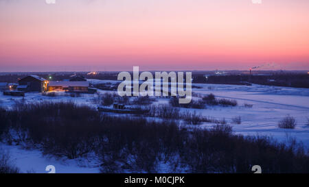 Herrliche winter Sonnenaufgang in Narian-Mar mit Schnee bedeckten Fluss Tanne Wald und Tundra. Great Outdoor Szene, natürliche Magenta, pink und blau Farben Stockfoto