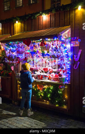 Ein Kind vor einem Zuckerstange und Süßigkeiten-Stand auf einem Weihnachtsmarkt (Altstadt, Stockholm, Schweden) Stockfoto