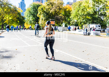 New York City, USA - Oktober 28, 2017: Midtown Manhattan mit Menschen eine Frau laufen, joggen, Turnen, Wandern am Central Park Road im Verkehr o Stockfoto