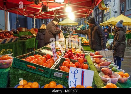 Marktstand ein Anbieter auf einer Obst und Gemüse stall bildet einen Verkauf im Surrey Street Market in Croydon, London. Stockfoto