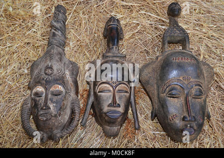 Afrikanische Masken auf einem Stroh Hintergrund. Stockfoto