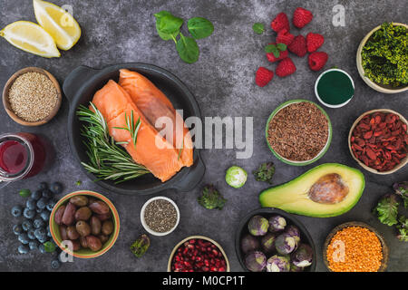 Fisch mit frische, gesunde Zutaten mit Samen, Hülsenfrüchte, Obst und Gemüse. Ansicht von oben, leeren Raum, rustikale Oberfläche Stockfoto