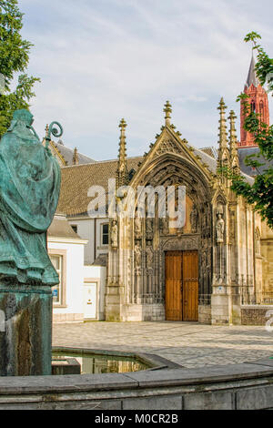 Mittelalterlichen Stadtplatz mit Eingang zu einer Basilika und vor Eine bronzene Statue des Hl. Servatius in Maastricht. Stockfoto