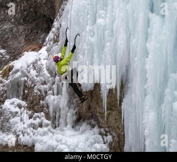Eiskletterer auf einem steilen gefrorenen Wasserfall im tiefen Winter in den Alpen in der Schweiz Stockfoto