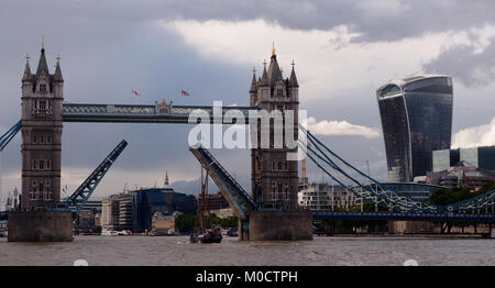 Ein Blick auf einem Segelschiff reisen West unter der Tower Bridge, London, mit der Brücke angehoben und der Londoner City im Hintergrund Stockfoto