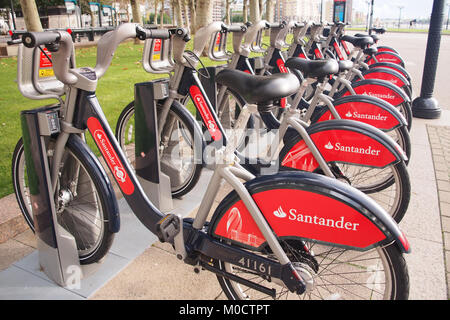 Eine Reihe von Santander London Fahrräder an eine Docking Station in der Nähe von Canary Wharf. Stockfoto