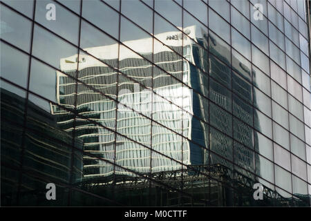 Eine Ansicht mit verzerrten Spiegelungen auf hohen, gläsernen Bürogebäuden im Finanzviertel von Canary Wharf, London Stockfoto