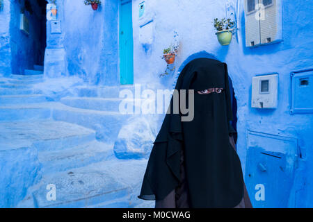 Muslimische Frau mit Gesicht mit schwarzen Niqab in Chefchaouen, die blaue Stadt bedeckt, in Marokko Stockfoto
