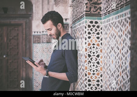 Junge arabische Mann bei der Arbeit auf Tablet Stockfoto