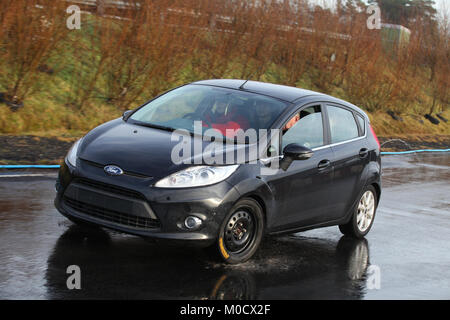 Ein junger Fahrer ist eine Anleitung, wie man ein Auto während Kurs an der Kompaktlader pan Mitte an der Rennstrecke Knockhill Racing Circuit in Fife, Schottland Stockfoto