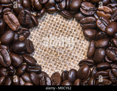 Geröstete Kaffeebohnen auf einer Leinwand Tuch warten auf Ihre Worte Stockfoto