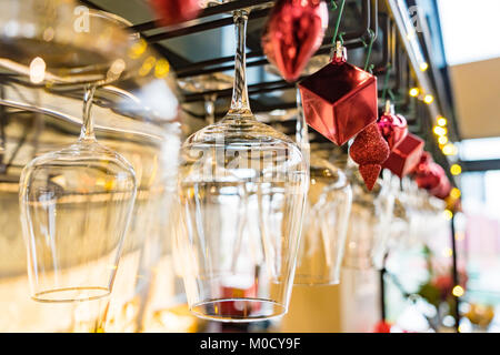 Leere Gläser Wein über einer Bar Rack auf dem Weihnachtsschmuck Hintergrund, selektiver Fokus Stockfoto