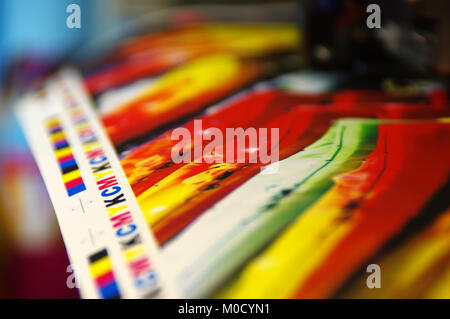 Drucken von CMYK-Markierung auf weißem Papier. Große digitale Drucker Maschine in der Druckerei. Stockfoto