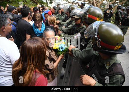 Caracas, Venezuela. 20 Jan, 2018. Ein Familienmitglied eines der Opfer gesehen, Blumen, die zur Teilnahme an der Beerdigung. Regierung von Nicolas Maduro, José Diaz Pimentel und Abraham Agostini ohne die Zustimmung der Familie beigesetzt. Pimentel und Agostini waren Teil der Rebellengruppe des Polizisten zusammen mit Oscar Perez wandte sich gegen die Maduro Regierung. 4 Leichen wurden in einen anderen Zustand des Landes und der Körper der Oscar Perez wird in Caracas begraben werden. Credit: Roman Camacho/SOPA/ZUMA Draht/Alamy leben Nachrichten Stockfoto