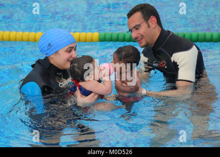 Kairo. 16 Jan, 2018. Kinder schwimmen mit ihren Trainerinnen in Kairo, Ägypten, Jan. 16, 2018. An einem kleinen geschlossen und Getäfelten hygienische Schwimmbad in einer Schule am Stadtrand von Kairo, ein Dutzend Eltern nahmen ihre Babys die spezielle schwimmkurse in der einzigartigen Zentrum von internationalen Babyschwimmen Trainer Mohamed Abdel-Maksoud zu besuchen. Credit: Ahmed Gomaa/Xinhua/Alamy leben Nachrichten Stockfoto