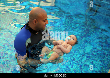 Kairo. 16 Jan, 2018. Ein Kind schwimmt mit einem Trainer in Kairo, Ägypten, Jan. 16, 2018. An einem kleinen geschlossen und Getäfelten hygienische Schwimmbad in einer Schule am Stadtrand von Kairo, ein Dutzend Eltern nahmen ihre Babys die spezielle schwimmkurse in der einzigartigen Zentrum von internationalen Babyschwimmen Trainer Mohamed Abdel-Maksoud zu besuchen. Credit: Ahmed Gomaa/Xinhua/Alamy leben Nachrichten Stockfoto