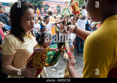 Philippinen. 21 Jan, 2018. Die katholischen Gläubigen um die Kirche von Sto gesammelt. Nino (Jesuskind) in Tondo Manila, wie sie das jährliche Festival feiern. Tausende bringen ihre eigenen Bilder und Statuen, die meisten von ihnen von Generation zu Generation weitergegeben, des Kindes Jesus als Priester die Bilder mit Weihwasser segnen. Credit: J Gerard Seguia/ZUMA Draht/Alamy leben Nachrichten Stockfoto