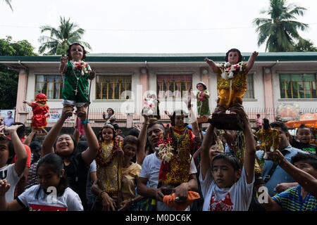 Philippinen. 21 Jan, 2018. Die katholischen Gläubigen um die Kirche von Sto gesammelt. Nino (Jesuskind) in Tondo Manila, wie sie das jährliche Festival feiern. Tausende bringen ihre eigenen Bilder und Statuen, die meisten von ihnen von Generation zu Generation weitergegeben, des Kindes Jesus als Priester die Bilder mit Weihwasser segnen. Credit: J Gerard Seguia/ZUMA Draht/Alamy leben Nachrichten Stockfoto