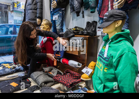 Thessaloniki, Griechenland - 19. Januar 2018: Frau schmückt Fenster präsentieren ein Bekleidungsgeschäft im Zentrum von Thessaloniki im Hinblick auf die winter Rabatte Stockfoto