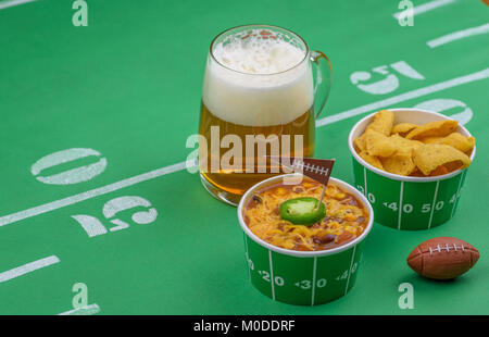 Schüssel mit Chili, Chips und Bier auf dem Tisch für Superbowl Partei eingerichtet Stockfoto