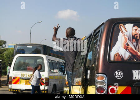 Ein Bus auf einer Straße mit dem Dirigenten in der Tür stehen für Passagiere, Nairobi, Kenia Stockfoto