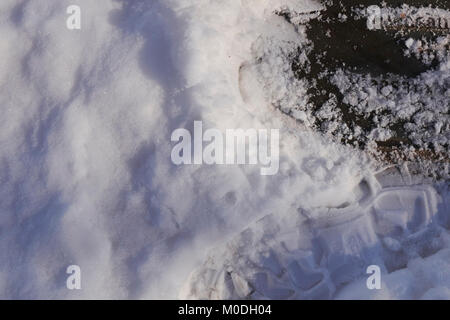 Unten und schauen Fußabdruck auf einem schneebedeckten Plakette Stockfoto