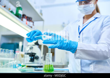 Wissenschaftlerin strömenden Flüssigkeiten im Labor Stockfoto