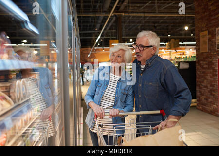 Gerne Älteres Paar beim Lebensmittelgeschäft triefend Stockfoto