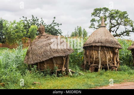 Zwei traditionelle afrikanische Getreidespeicher aus Holz und Stroh in einem Feld von Hirse, Ouagadougou, Burkina Faso. Stockfoto