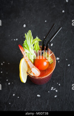 Bloody Mary Cocktail in Glas mit Beilagen. Tomate Bloody Mary würzige Drink auf schwarzen Hintergrund mit kopieren. Stockfoto