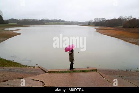 Ein junges Mädchen, Spaziergänge entlang der Kante des Bewl Wasserbehälter bei starkem Regen in der Nähe von Lamberhurst, Kent, nach Süden Wasser war eine Dürre von der Umweltagentur dem Behälter vom Fluss Medway zu Befüllen nach Berichterstattung außergewöhnlich niedrige Wasserstände gewährt. Stockfoto